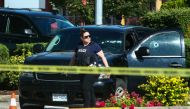A police officer walks next to a car with bullet holes on the windows at a crime scene after authorities alerted residents of multiple shootings targeting transient victims in the Vancouver suburb of Langley, British Columbia, Canad, July 25, 2022. (REUTERS/Jesse Winter)
