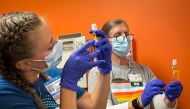 Dr Emily Drwiega from the University of Illinois Health and Maggie Butler, a registered nurse, prepare monkeypox vaccines at the Test Positive Aware Network nonprofit clinic in Chicago, Illinois, US, July 25, 2022. (REUTERS/Eric Cox)