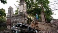 A man inspects a damaged car in the aftermath of an earthquake in Vigan City, Ilocos Sur, Philippines, July 28, 2022. REUTERS/Lisa Marie David