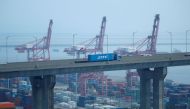 A truck carrying a shipping container travels past cranes at Pyeongtaek port in Pyeongtaek, South Korea, July 9, 2020. REUTERS/Kim Hong-Ji/File Photo


