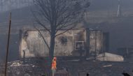 A member of a search and rescue team walks along an area destroyed by the McKinney Fire near Yreka, California, U.S., August 1, 2022. REUTERS/Carlos Barria