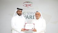 Khalifa Abdulla Turki Al Subaey (right), Chairman & Managing Director of QIC Group, hands over a long service award to Salem Al Mannai, QIC Group CEO, recently.  