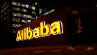 A man walks past a logo of Alibaba Group at its office building in Beijing, China August 9, 2021. REUTERS/Tingshu Wang/

