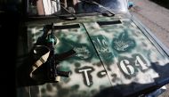 A weapon of Ukrainian serviceman is seen on a car bonnet painted with tanks, as Russia's invasion of Ukraine continues, in Kharkiv, Ukraine, August 7, 2022. (REUTERS/Nacho Doce)