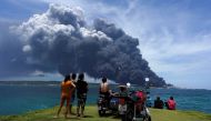 People watch smoke over fuel storage tanks that exploded near Cuba's supertanker port in Matanzas, Cuba, August 8, 2022. (REUTERS/Alexandre Meneghini)