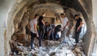 Palestinians inspect a building damaged during clashes between Palestinian militants and Israeli forces in a raid, in Nablus in the Israeli-occupied West Bank, August 9, 2022. (REUTERS/Raneen Sawafta)