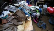 An employee of a herbal medicine shop cleans up debris at a traditional market damaged by flood after torrential rain, in Seoul, South Korea, August 9, 2022. REUTERS/Kim Hong-Ji/File Photo