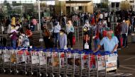 An airport staff member pushes trollies at the entrance of Chhatrapati Shivaji International Airport, after the government allowed domestic flight services to resume, during an extended nationwide lockdown to slow the spread of the coronavirus disease (COVID-19), in Mumbai, India, May 25, 2020. REUTERS/Francis Mascarenhas/File Photo