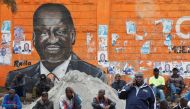 People sit next to a wall mural of Raila Odinga the presidential candidate for Azimio la Umoja and One Kenya Alliance in Kibera slums of Nairobi, Kenya August 12, 2022. Reuters/Monicah Mwangi