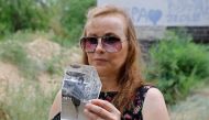 Lilia Ai-Talatini, 48, holds a picture of her mother, Ekaterina Yatsyuk in the Luhansk region, Ukraine August 12, 2022. Reuters/Alexander Ermochenko