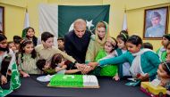 Ambassador H E Syed Ahsan Raza Shah hoisting the national flag and cutting a cake to mark 76th independence day of Pakistan at the Embassy of Pakistan in Doha yesterday. 