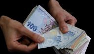 File photo: Hand counting Turkish lira banknotes
