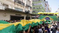 Supporters carry a flag as they attend a campaign rally of Brazil's President and candidate for re-election Jair Bolsonaro, in Juiz de Fora, Brazil, August 16, 2022. (REUTERS/Ricardo Moraes)

