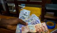 A man trades U.S. dollars for Ghanaian cedis at a currency exchange office in Accra, Ghana, File. REUTERS/Francis Kokoroko

