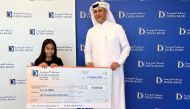 Braik Al Marri, Chief Retail Banking Officer at Doha Bank awards a winner of the 4th Al Dana draw, in Doha, recently. 