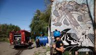 Emergency Service workers fill up a water deposit, as Russia's attack on Ukraine continues, in Toretsk, Donetsk region, Ukraine on Monday. REUTERS/Ammar Awad