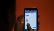 A customer holds the Open G smartphone, which can speak local Ivorian languages, at a shop in Abidjan, Ivory Coast July 25, 2022. REUTERS/Luc Gnago