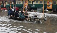 People ride on a donkey cart along a flooded road, following rains during the monsoon season in Hyderabad, Pakistan, August 24, 2022. (REUTERS/Yasir Rajput) 