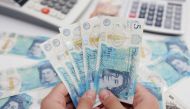 Woman holds British Pound banknotes in this illustration taken on May 30, 2022. REUTERS/Dado Ruvic/Illustration