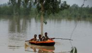 A volunteer rows an inflatable boat as he evacuates flood victims, following rains and floods during the monsoon season in Charsadda, Pakistan August 27, 2022. REUTERS/Fayaz Aziz
