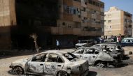 People gather next to burnt cars after yesterday's clashes in Tripoli, Libya. August 28, 2022. (REUTERS/Hazem Ahmed)