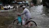 A man rides bicycle along a flooded road, following heavy rains during the monsoon season in Karachi, Pakistan July 25, 2022. REUTERS/Akhtar Soomro