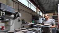 An employee works at a ceramics factory where the workers start their shifts before dawn to optimise sunlight and save energy, in Citta di Castello, Italy, August 30, 2022. REUTERS/Jennifer Lorenzini