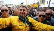 Brazil's President Jair Bolsonaro greets supporters while he is escorted by members of presidential security during the 45th Expointer agricultural fair in Esteio, Brazil, on September 2, 2022. REUTERS/Diego Vara/File Photo