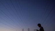 A man walks by power lines, as California's grid operator urged the state's 40 million people to ratchet down the use of electricity in homes and businesses as a wave of extreme heat settled over much of the state, in Mountain View, California, U.S., August 17, 2022. REUTERS/Carlos Barria/File Photo

