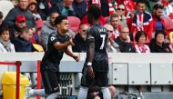 Arsenal's Ethan Nwaneri (left) shakes hands with Bukayo Saka as he comes on as a substitute during their EPL match against Brentford at the Brentford Community Stadium in London on September 18, 2022.   REUTERS/David Klein
