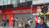 People wearing face masks, following the coronavirus disease outbreak, walk past a closed cinema in Hong Kong on February 16, 2022. File Photo / Reuters
