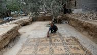 Palestinian farmer Salman al-Nabahin cleans a mosaic floor he discovered at his farm and which dates back to the Byzantine era, according to officials, in the central Gaza Strip, on September 18, 2022. (REUTERS/Ibraheem Abu Mustafa)