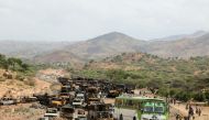 Villagers return from a market to Yechila town in south central Tigray walking past scores of burned vehicles, in Tigray, Ethiopia, on July 10, 2021. File Photo / Reuters
