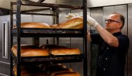 Owner Dennis Toebast takes the bread out of the oven at his bakery in Hoevelaken, Netherlands September 21, 2022. Reuters/Piroschka van de Wouw
 