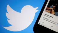 A promoted tweet on China's Suzhou city is displayed on a mobile phone near a Twitter logo, in this illustration picture taken on September 8, 2022. REUTERS/Florence Lo