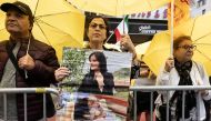 A demonstrator holds a picture of Mahsa Amini, who died in police custody in Iran, in New York City on September 22, 2022. REUTERS/Caitlin Ochs