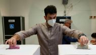 A man drops ballots into boxes at a polling station during the snap election, in Rome, Italy, September 25, 2022. Reuters/Remo Casilli
