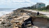 Onlookers view a washed out portion of State Highway A1A in the aftermath of Hurricane Matthew in Flagler Beach, Florida, on October 8, 2016.   File Photo/ Reuters

