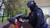 A person shows a passport to a Russian law enforcement officer during a rally, after opposition activists called for street protests against the mobilisation of reservists ordered by President Vladimir Putin, in Moscow on September 24, 2022. REUTERS/REUTERS PHOTOGRAPHER