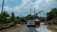 File photo: Cars drive under a downed power pole in the aftermath of Hurricane Fiona in Santa Isabel, Puerto Rico September 21, 2022. Reuters/Ricardo Arduengo/File Photo