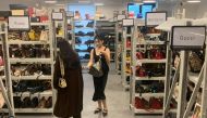Customers look at bags displayed at a store of second-hand luxury goods platform ZZER in Shanghai, China September 9, 2022. Reuters/Xihao Jiang