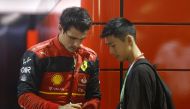 Ferrari's Carlos Sainz Jr. signs a cap for a fan after the second practice session for the Singapore Grand Prix in Marina Bay Street Circuit, Singapore, on September 30, 2022. (REUTERS/Edgar Su)