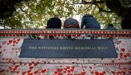 Photographs are left at the National Covid Memorial Wall, a dedication of thousands of hand painted hearts and messages commemorating victims of the Covid-19 pandemic, in London, Britain, October 4, 2022. (REUTERS/Peter Nicholls)