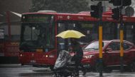 A pedestrian pushing a baby pram crosses a flooding intersection as heavy rains affect Sydney, Australia, October 6, 2022. REUTERS/Loren Elliott