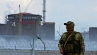 A serviceman with a Russian flag on his uniform stands guard near the Zaporizhzhia Nuclear Power Plant in the course of Ukraine-Russia conflict outside the Russian-controlled city of Enerhodar in the Zaporizhzhia region, Ukraine, August 4, 2022. (REUTERS/Alexander Ermochenko)