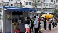 People line up to get a swab at a nucleic acid testing station set up to trace possible coronavirus disease (COVID-19) outbreaks in Beijing, China, October 7, 2022. REUTERS/Thomas Peter