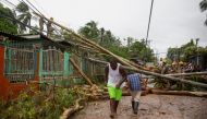 People walk near trees and light poles downed in the aftermath of Hurricane Julia, in Bluefields, Nicaragua October 9, 2022. REUTERS/Maynor Valenzuela