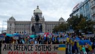 Protesters hold signs during a rally to condemn recent Russian widespread missile strikes on Ukraine, in Prague, Czech Republic, on October 10, 2022. REUTERS/David W Cerny