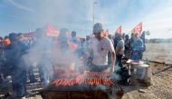 Demonstrators cook sausages during a TotalEnergies and Esso ExxonMobil workers' protest outside TotalEnergies refinery in La Mede, France, on October 11, 2022. REUTERS/Eric Gaillard