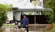 A man pushes a boat as floodwaters inundate a Victorian residential area amidst evacuation orders in Rochester, Australia, October 14, 2022. AAP Image/James Ross via REUTERS